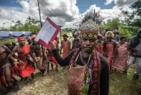 Ketua Dewan Persekutuan Masyarakat Adat Fredik Sagisolo (kanan) memegang surat keputusan saat merayakan upacara di Teminabuan, Sorong Selatan, Papua Barat Daya. Masyarakat Adat Tehit-Knasaimos mempunyai hak atas tanah adat mereka yang diakui oleh hukum Indonesia. Foto : Greenpeace Indonesia