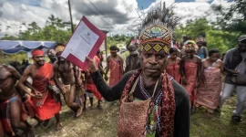 Ketua Dewan Persekutuan Masyarakat Adat Fredik Sagisolo (kanan) memegang surat keputusan saat merayakan upacara di Teminabuan, Sorong Selatan, Papua Barat Daya. Masyarakat Adat Tehit-Knasaimos mempunyai hak atas tanah adat mereka yang diakui oleh hukum Indonesia. Foto : Greenpeace Indonesia