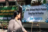 Warga perhtikan karangan bunga yang terpajang di depan Gedung PN Surabaya, Jalan Arjuno, Surabaya, Jawa Timur, Senin (29/7).(Antara/Didik Suhartono)