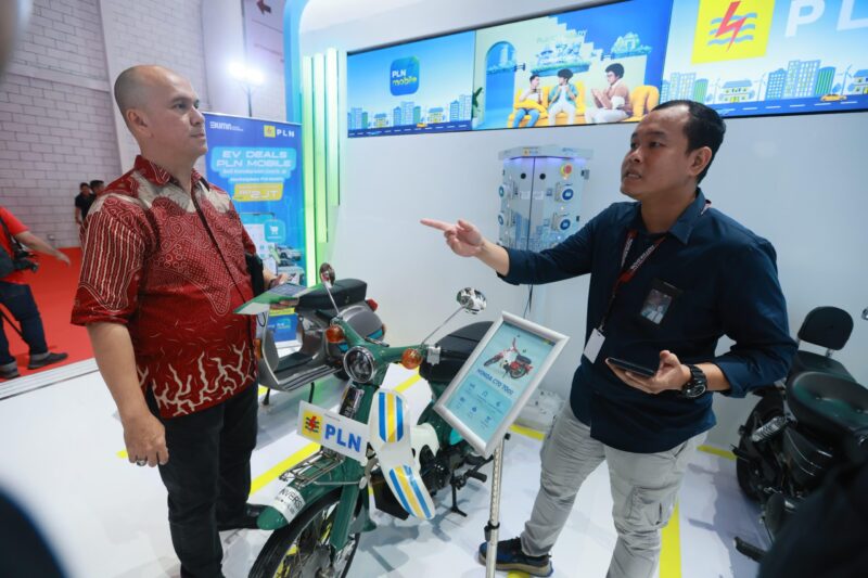 Para pengunjung IIMS 2025 antusias melihat display motor konversi listrik di booth PLN.